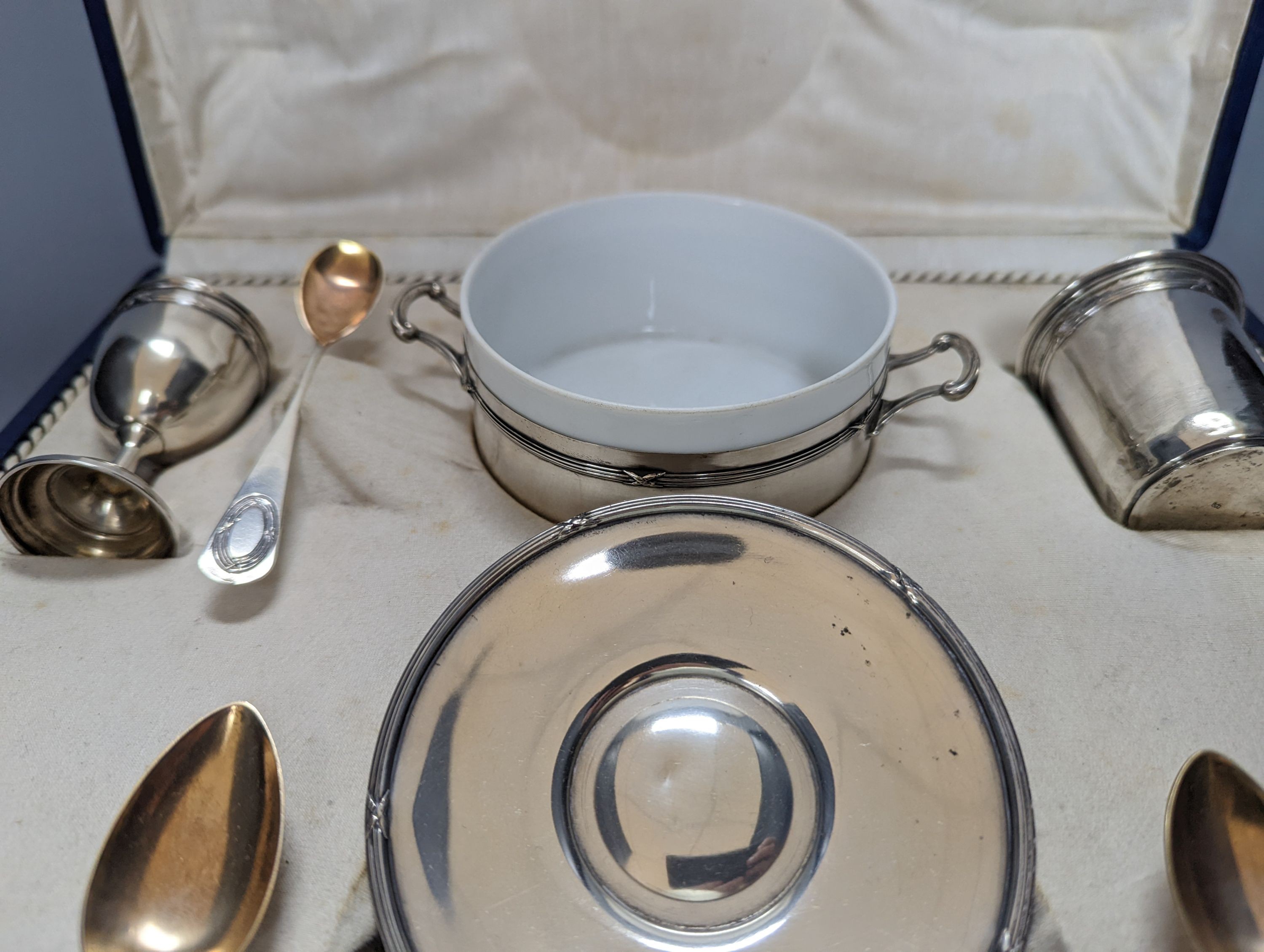 A cased part German 800 white metal mounted ceramic part tea set (incomplete), metal weight 5.5oz.